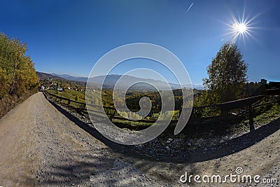 Very wide shot of a dirt road leading to a rural mountain village Stock Photo