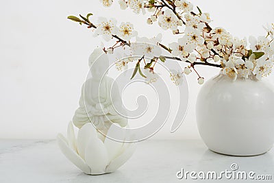 Vesak, Wesak, Buddha birthday. Buddha statue with blossoming cherry on white background. Spa ritual. Mental health and Stock Photo