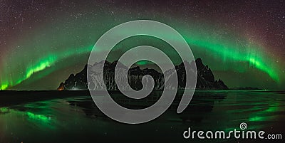 Vestrahorn Stockknes mountain range with aurora borealis and reflection at the beach in Iceland. One of the most Stock Photo