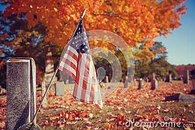 Veteran flag in autumn cemetery Stock Photo