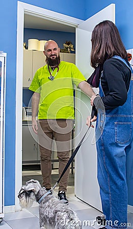 Veterinarian receiving a client with her pet Stock Photo