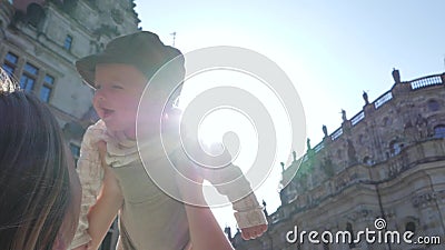 Viajando com crianças, a mãe joga com o filho novo na rua no luminoso no fundo do céu filme Viajando com crianças, a mãe joga com o filho novo na rua no luminoso no fundo do céu filme