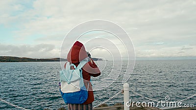 Viajera toma foto del mar por cámara retro en muelle de madera en otoño almacen de video Viajera toma foto del mar por cámara retro en muelle de madera en otoño almacen de video