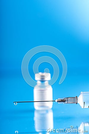 Vial with Covid-19 vaccine and a syringe with a drop of vaccine on the needle Stock Photo