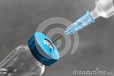 Vial with vaccine and syringe on grey background Stock Photo
