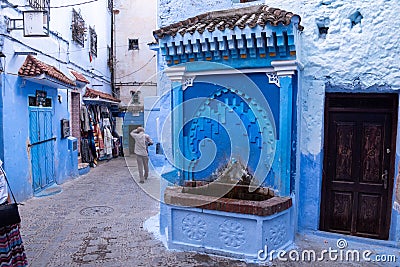 Vibrant blue colored alley with a fountain in downtown Chefchaouen Editorial Stock Photo