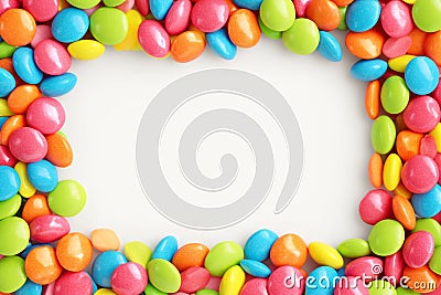 Vibrant candy frame Close up of rainbow colored dragee on white Stock Photo