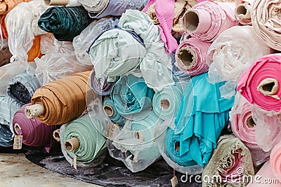 Vibrant collection of multicolored fabric rolls and swatches, arranged in a neat pile Stock Photo