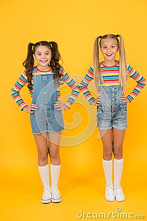 Vibrant colors. Modern fashion. Kids fashion. Girls long hair. Cute children same outfits. Little girls wearing rainbow Stock Photo