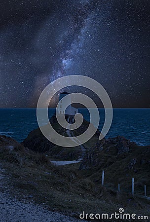 Vibrant Milky Way composite image over landscape of lighthouse on end of headland with beautiful sky Stock Photo