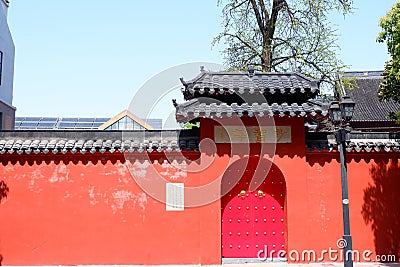 Vibrant red doorway with the black roof of the Pilu temple in China Editorial Stock Photo