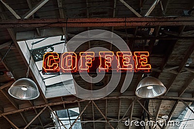 Vibrant red neon coffee sign hanging from the ceiling in industrial style. Editorial Stock Photo