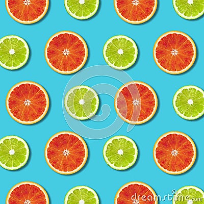 Vibrant red orange and green lime lemon slices pattern on turquoise background Stock Photo