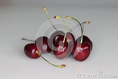 Vibrant, succulent cherries nestled together in a delightful cluster, showcasing rich hues of red against lush green stems Stock Photo