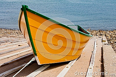 Vibrant, yellow fishing dory with green trim. Stock Photo