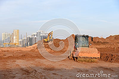 Vibration single-cylinder road roller leveling the ground for the foundation. Soil Compactor Stock Photo