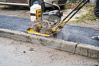 vibratory plate, a construction tool that performs trambing work of pavement Stock Photo