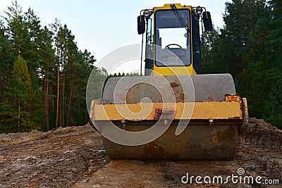 Vibro Roller Soil Compactor at road construction and bridge projects in forest area. Heavy machinery for road work. Building a Stock Photo