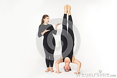 Vice versa. Woman showing at man, stand on head Stock Photo