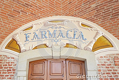 Arcade in red bricks around Sanctuary of Vicoforte church, ancient pharmacy sign in Piedmont, Italy Editorial Stock Photo