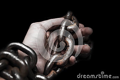 Victim, slave, prosoner male hands tied by big metal chain by hi Stock Photo