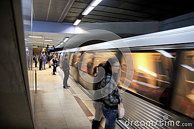 Subway train leaving the station and people waiting for the next one Editorial Stock Photo