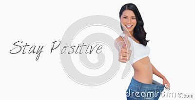 Victorious woman holding her too big pants thumbs up Stock Photo