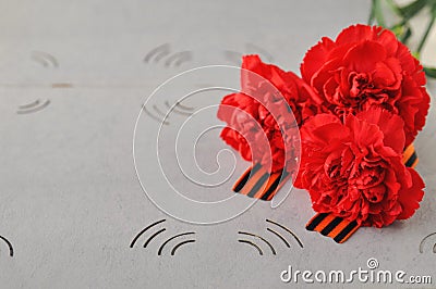 May 9 Victory day card. Red carnations and St. George ribbon on the background of an old photo album. Day of memory and military Stock Photo