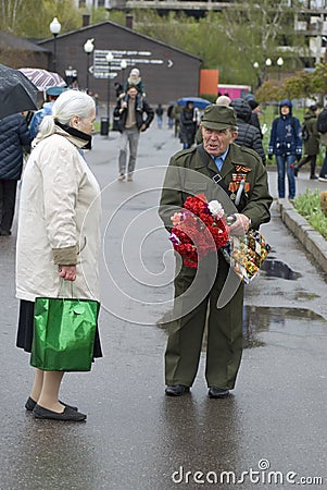 Victory Day celebration in Moscow. Senior man holds many flowers Editorial Stock Photo