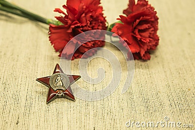 Victory Day. We remember the exploits of our grandfathers. Order of the red star on the background of carnations Stock Photo