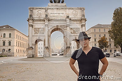 Victory Gate triumphal arch Siegestor in Munich, Germany. Tourist man in front of attraction landmark travel background. Stock Photo