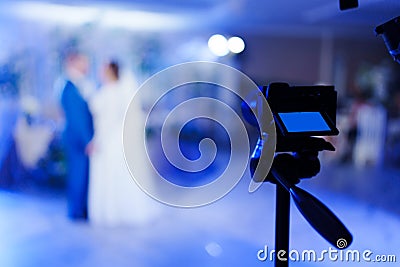 A video camera is filming the dance of the bride and groom. Selective focus. Stock Photo