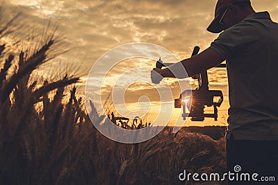 Video Camera Operator with Gimbal Stabilization Taking Scenic Sunset Shot Stock Photo