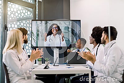 Video conference, telemedicine. Multiethnical medical scientific team applauding during a video conference with their Stock Photo