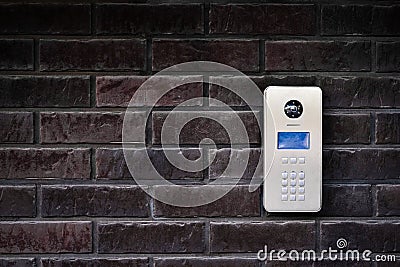 Video intercom on dark brick wall background. Modern, luxury, wealthy home security system. Alarm door bell. Safe entrance Stock Photo
