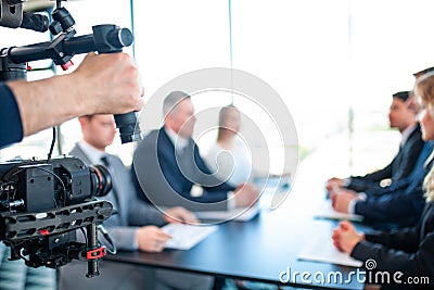 Videographer filming business meeting Stock Photo