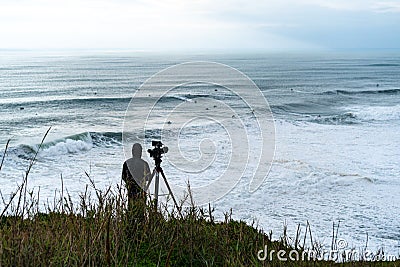 videographer filming surfers in Nazare Stock Photo