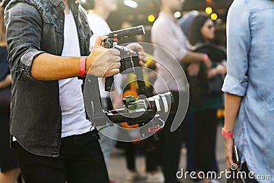 Videographer with gimball video DSLR in an event among people Stock Photo