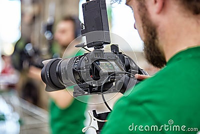Videographer shooting a film or a television program in a studio with a professional camera, backstage Stock Photo