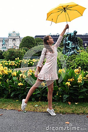 VIENNA, AUSTRIA. A girl with a yellow umbrella on the background of the Neue Burg, a new castle of the Hofburg P Stock Photo