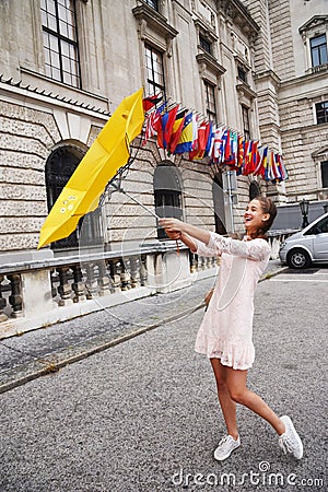 VIENNA, AUSTRIA. A girl with a yellow umbrella on the background of the Neue Burg, a new castle of the Hofburg P Stock Photo