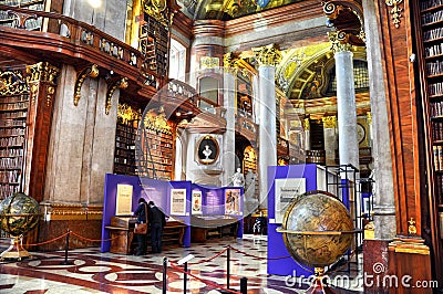 VIENNA, AUSTRIA - MAY 04, 2014: Old bookshelfs with ladder and books inside the Austrian National library. Tourist visits exhibit. Editorial Stock Photo