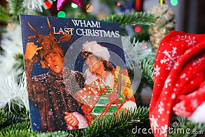 Close up of vintage vinyl record cover single with famous Wham last christmas song in decorated fir tree Editorial Stock Photo