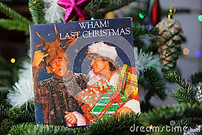 Close up of vintage vinyl record cover single with famous Wham last christmas song in decorated fir tree Editorial Stock Photo