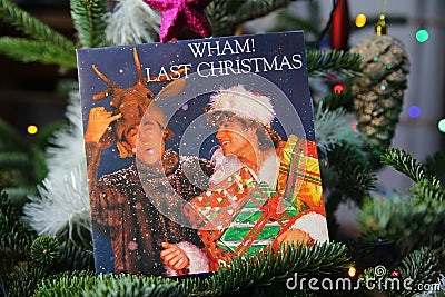 Close up of vintage vinyl record cover single with famous Wham last christmas song in decorated fir tree Editorial Stock Photo