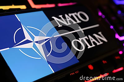 Smartphone screen with logo lettering of NATO OTAN on computer keyboard Editorial Stock Photo