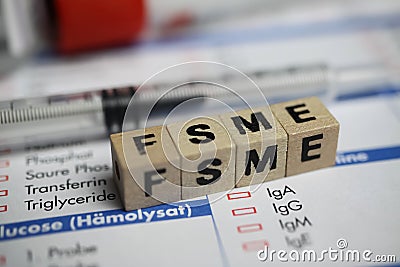 Closeup of word FSME on laboratory requisition slip with syringe and vial Editorial Stock Photo