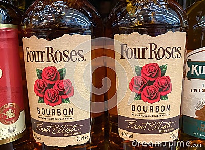 Closeup of four roses bourbon whiskey bottles in shelf of german supermarket Editorial Stock Photo