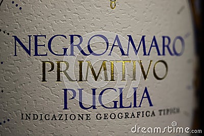 Closeup of isolated italian negroamaro primitivo puglia red wine bottle label with golden and blue letters Editorial Stock Photo
