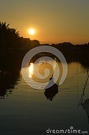 Small rowing fishing boat in silhouette at sunset Hoi An VIetnam Editorial Stock Photo